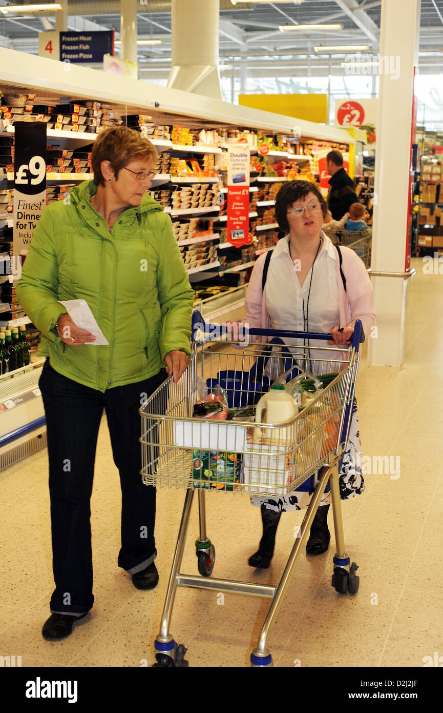Eine junge Frau mit Lernschwierigkeiten einkaufen gehen mit ihrer Unterstützung Arbeiter, Skipton, North Yorkshire. Stockfoto