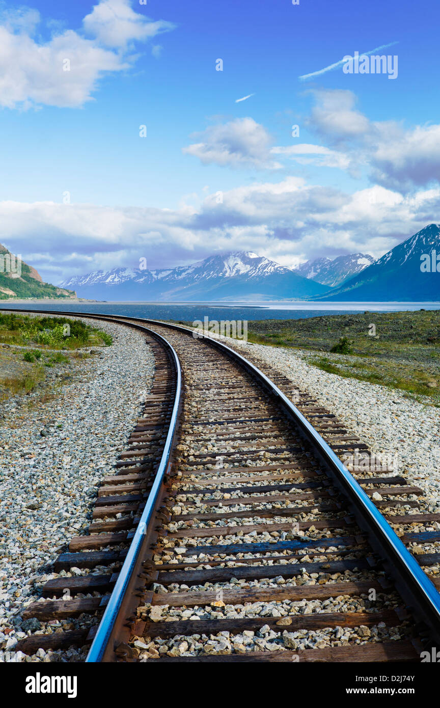 Eisenbahnschienen säumen die zerklüftete Landschaft von Meer und Bergen, Turnagain Arm, südlich von Anchorage, Alaska, USA Stockfoto