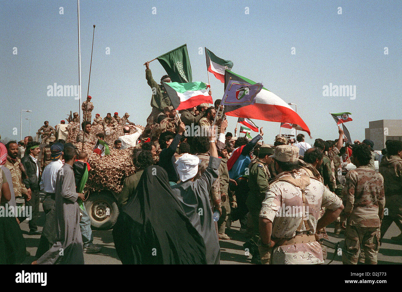 Zivilisten und militärische Koalition zwingt Welle Kuwait, Saudi-Arabien und anderen Flags wie Feiern sie den Rückzug der irakischen Truppen aus Kuwait als Folge der Operation Desert Storm Februar 28, 1991 in Kuwait-Stadt. Stockfoto