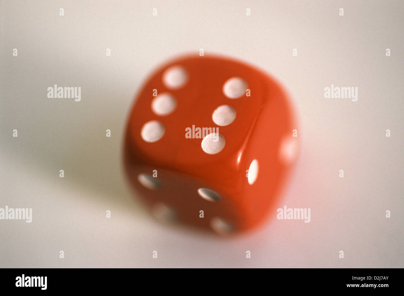 Roter genoppter das sechsseitige Würfel mit abgerundeten Ecken. Stockfoto