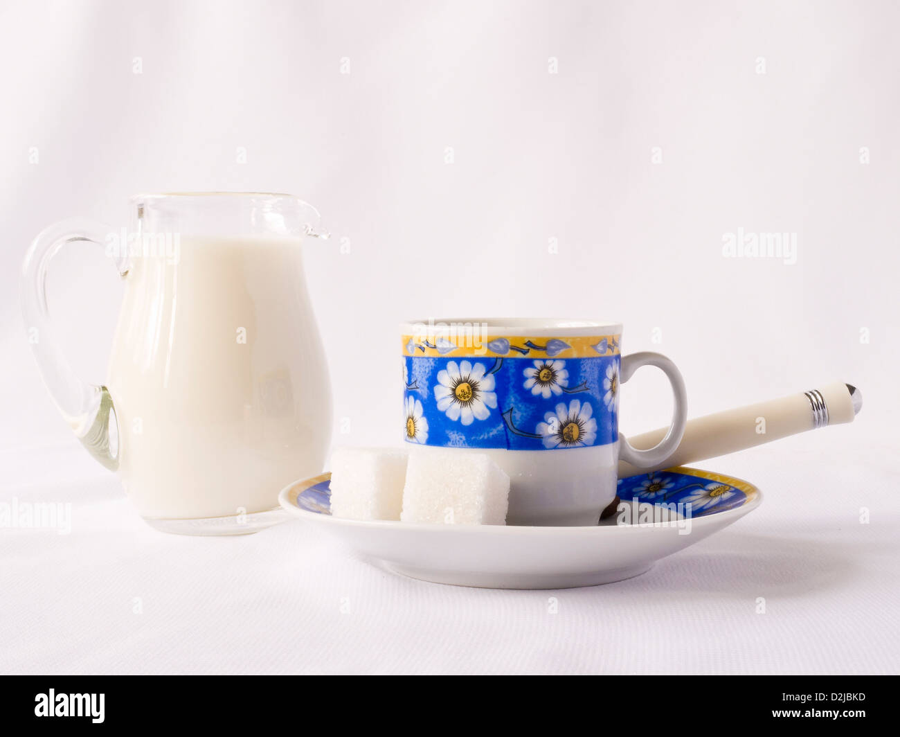 Tasse, Milch und Zucker auf weißem Hintergrund Stockfoto