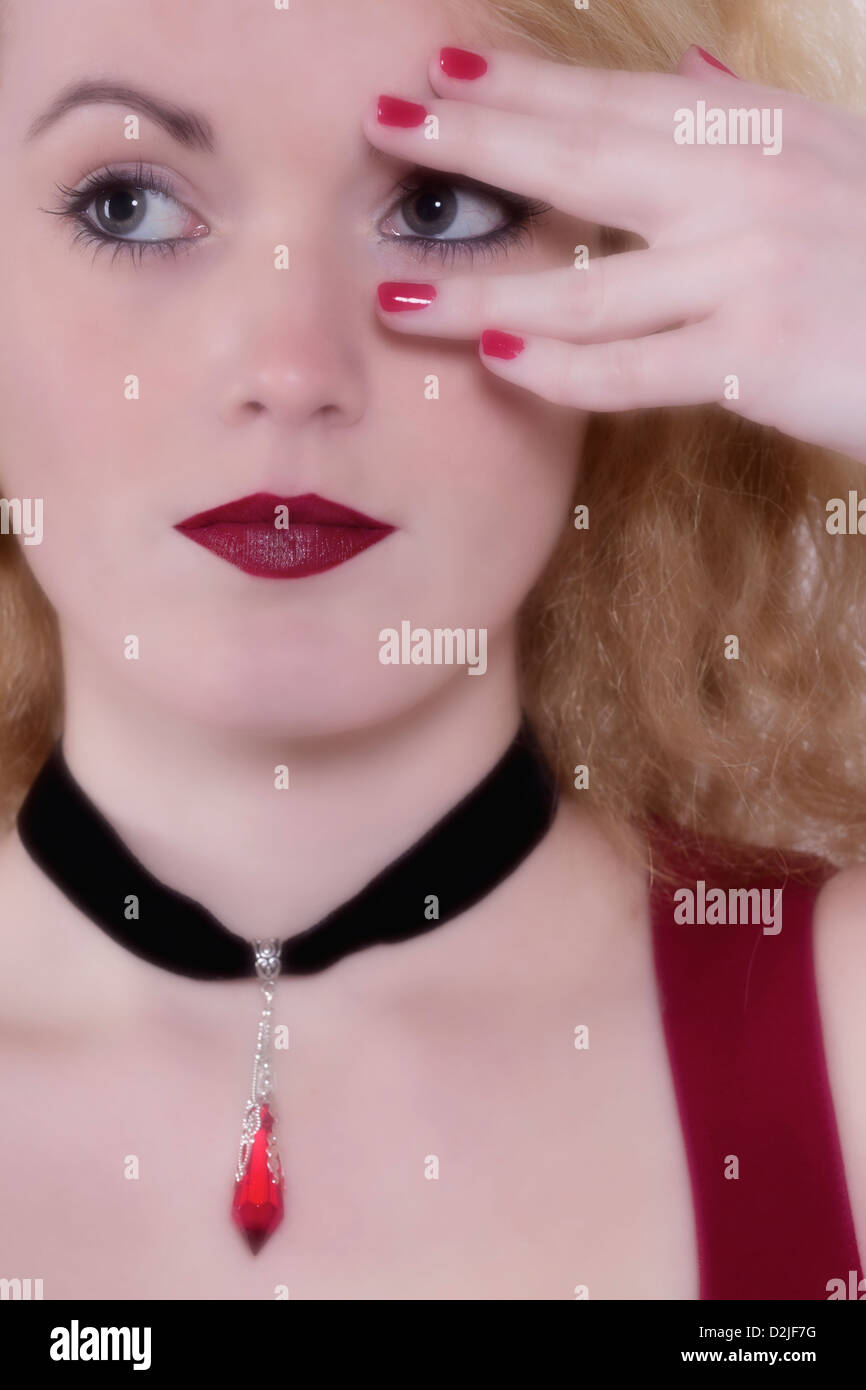 eine Mädchen sucht durch ihre Finger Stockfoto