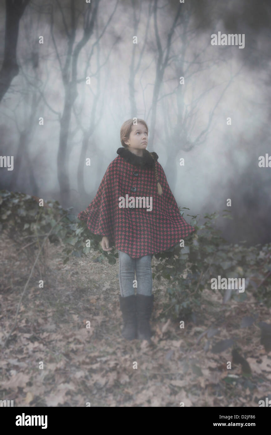 ein Mädchen mit einem roten Umhang in den dunklen Wäldern Stockfoto