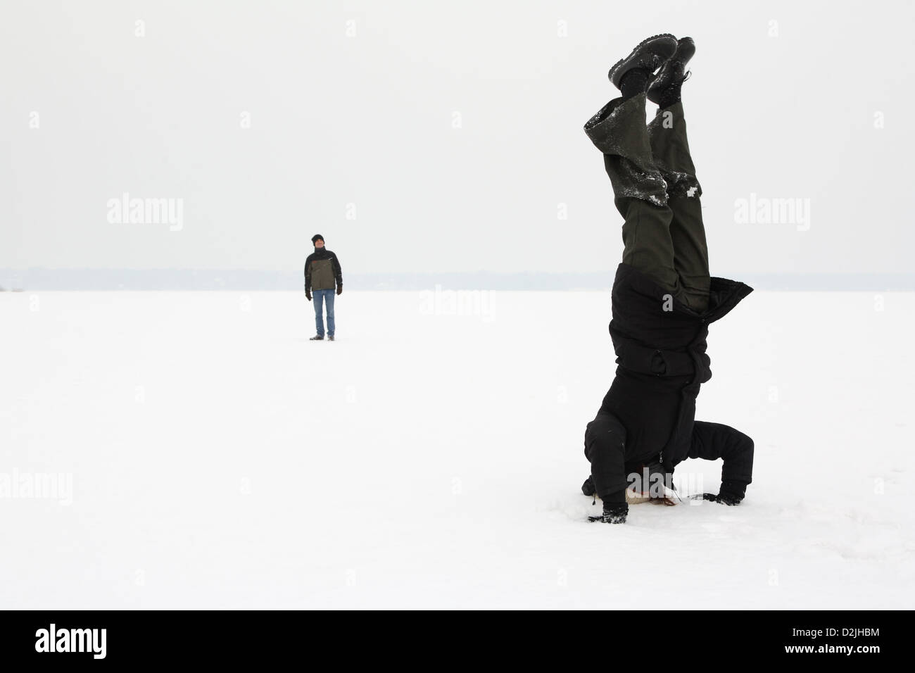 Berlin, Deutschland, Frau macht einen Kopfstand im Schnee Stockfoto