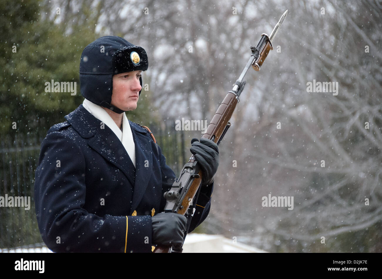 ARLINGTON Virginia // ARLINGTON, Virginia — Ein Soldat steht während des Schneefalls am Grab der Unbekannten auf dem Arlington National Cemetery. Der Wächter des 3. US-Infanterieregiments behält die zeremonielle Wache trotz Winterwetter. Die Wache folgt einer präzisen 21-stufigen Routine, marschiert entlang der schwarzen Matte hinter dem Grab, bevor sie sich für 21 Sekunden nach Osten und dann für 21 Sekunden nach Norden wendet. Das Grab des unbekannten Soldaten wird seit 1937 24 Stunden am Tag, 365 Tage im Jahr bewacht. Stockfoto