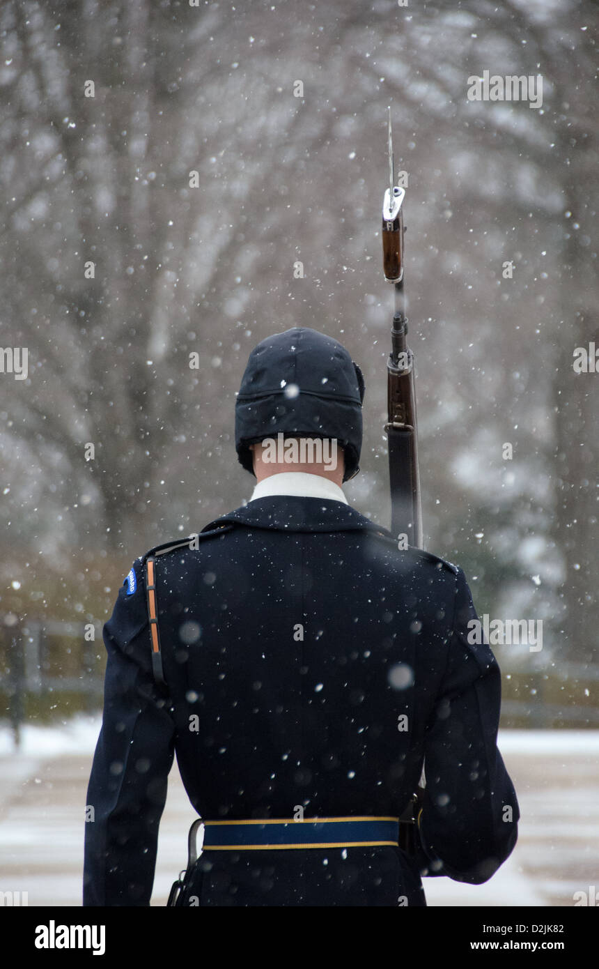 ARLINGTON Virginia // ARLINGTON, Virginia — Ein Soldat steht während des Schneefalls am Grab der Unbekannten auf dem Arlington National Cemetery. Der Wächter des 3. US-Infanterieregiments behält die zeremonielle Wache trotz Winterwetter. Die Wache folgt einer präzisen 21-stufigen Routine, marschiert entlang der schwarzen Matte hinter dem Grab, bevor sie sich für 21 Sekunden nach Osten und dann für 21 Sekunden nach Norden wendet. Das Grab des unbekannten Soldaten wird seit 1937 24 Stunden am Tag, 365 Tage im Jahr bewacht. Stockfoto