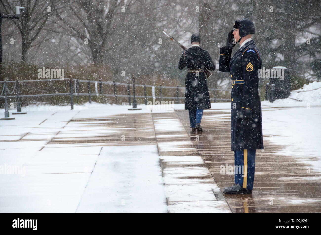 ARLINGTON Virginia // ARLINGTON, Virginia — Ein Soldat steht während des Schneefalls am Grab der Unbekannten auf dem Arlington National Cemetery. Der Wächter des 3. US-Infanterieregiments behält die zeremonielle Wache trotz Winterwetter. Die Wache folgt einer präzisen 21-stufigen Routine, marschiert entlang der schwarzen Matte hinter dem Grab, bevor sie sich für 21 Sekunden nach Osten und dann für 21 Sekunden nach Norden wendet. Das Grab des unbekannten Soldaten wird seit 1937 24 Stunden am Tag, 365 Tage im Jahr bewacht. Stockfoto