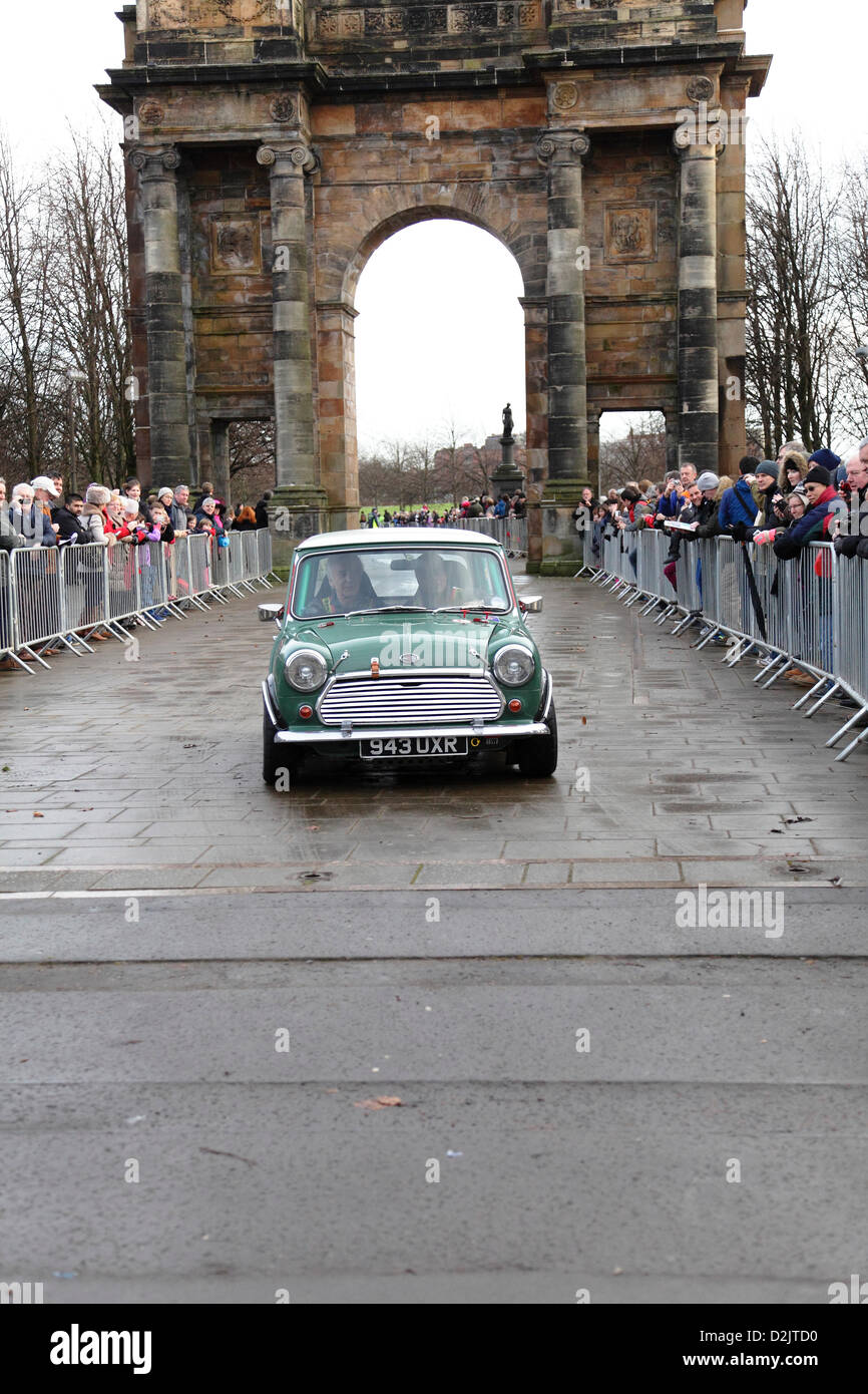 Glasgow Green, Glasgow, Schottland, Großbritannien, Samstag, 26. Januar 2013. Zuschauer beobachten einen Mini Cooper, der nach dem Start der Monte Carlo Classic Rallye mit dem McLennan Arch im Hintergrund abfährt Stockfoto