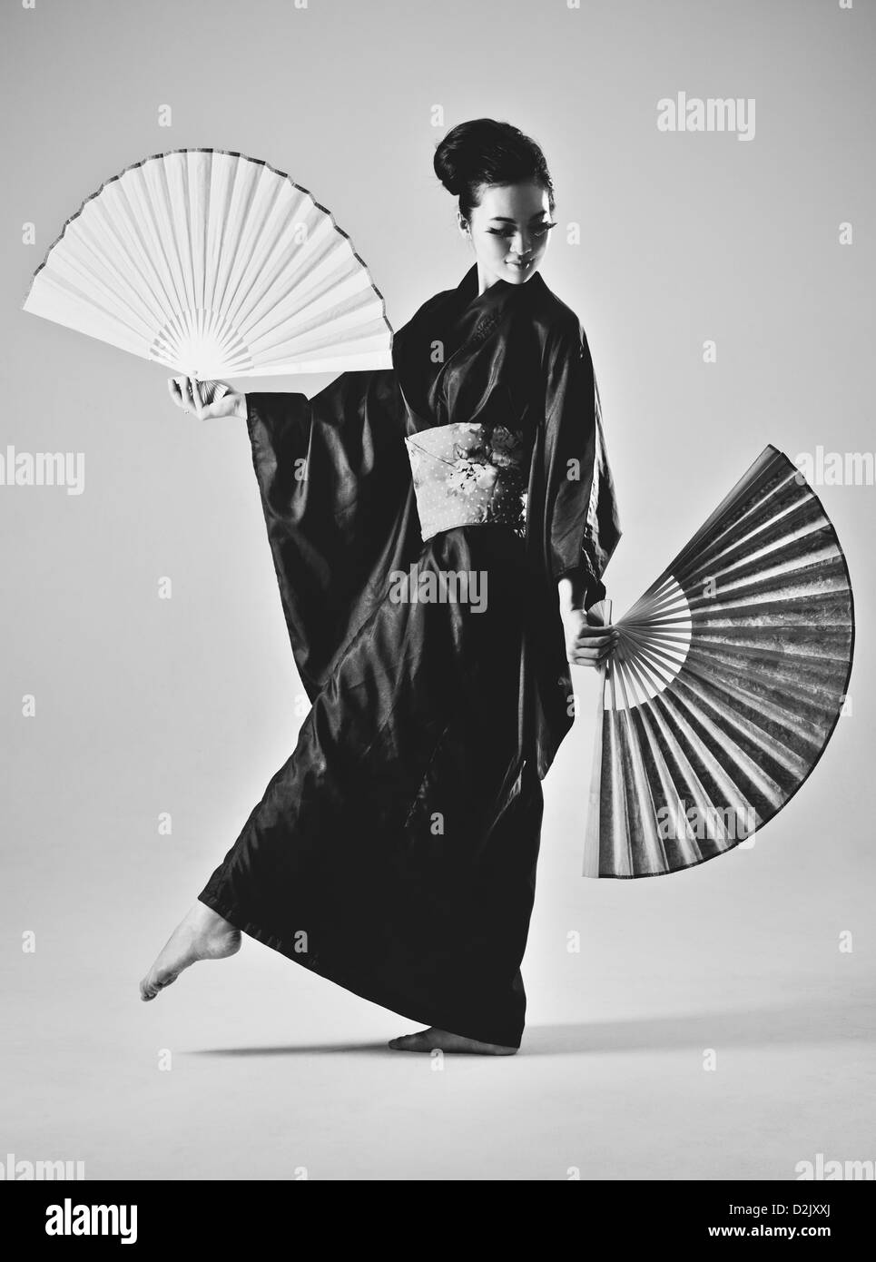 Junge Japanerin mit Fans. Schwarz / weiß-Film-Stil-Farben. Stockfoto