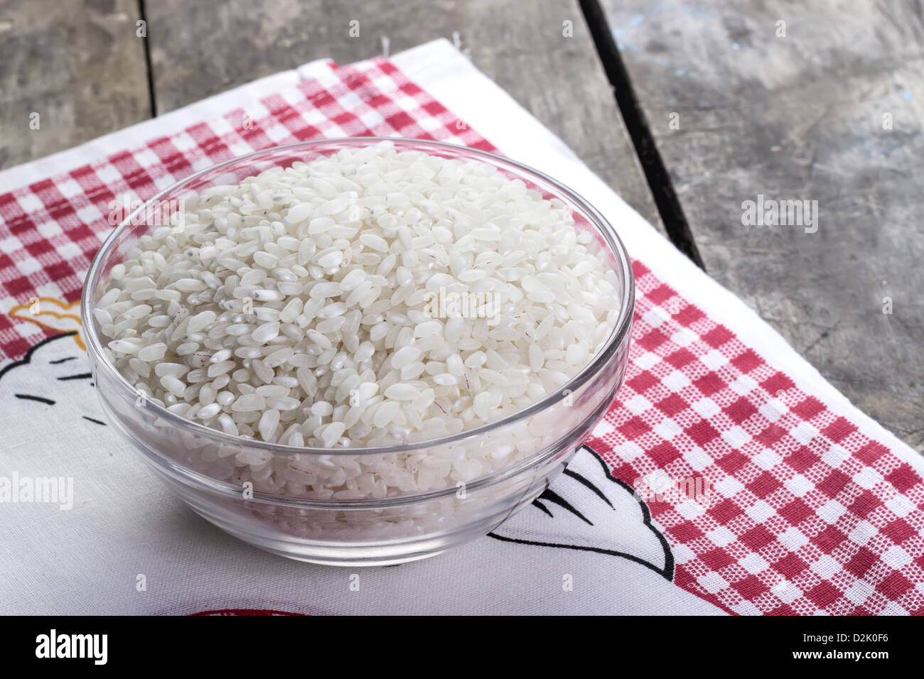 Reis in eine Glasschüssel auf alten Holztisch Stockfoto