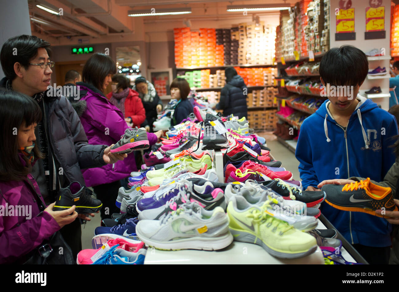 Chinesische Kunden durchsuchen einen Nike Store in Peking, China. 26. Januar 2013 Stockfoto