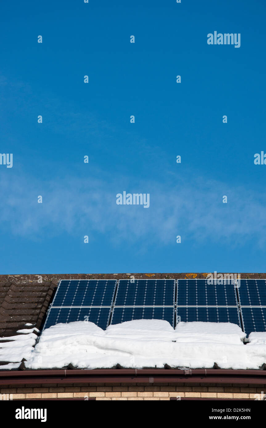 Inländische Sonnenkollektoren auf dem Dach des Hauses mit Schnee Stockfoto