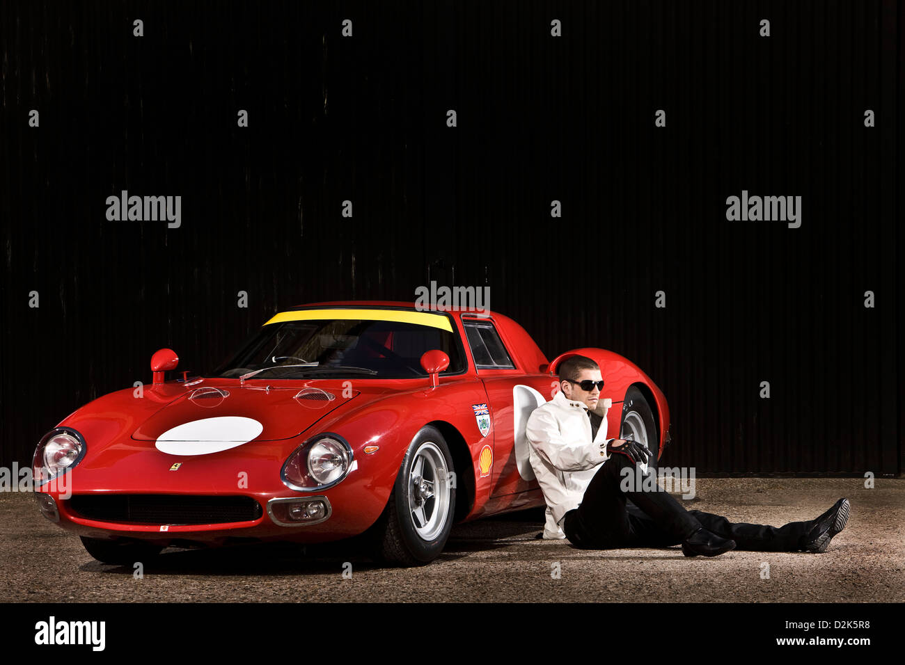Mann, sitzend mit roten Sportwagen von Ferrari Coupe 250 LM Stockfoto