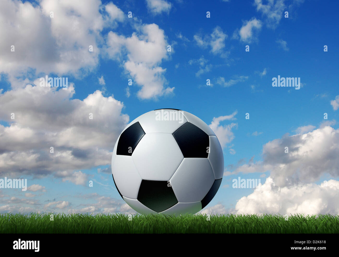 Fußball auf dem Rasen mit Himmel und Wolken im Hintergrund. Erdgeschoss-Seitenansicht. Stockfoto