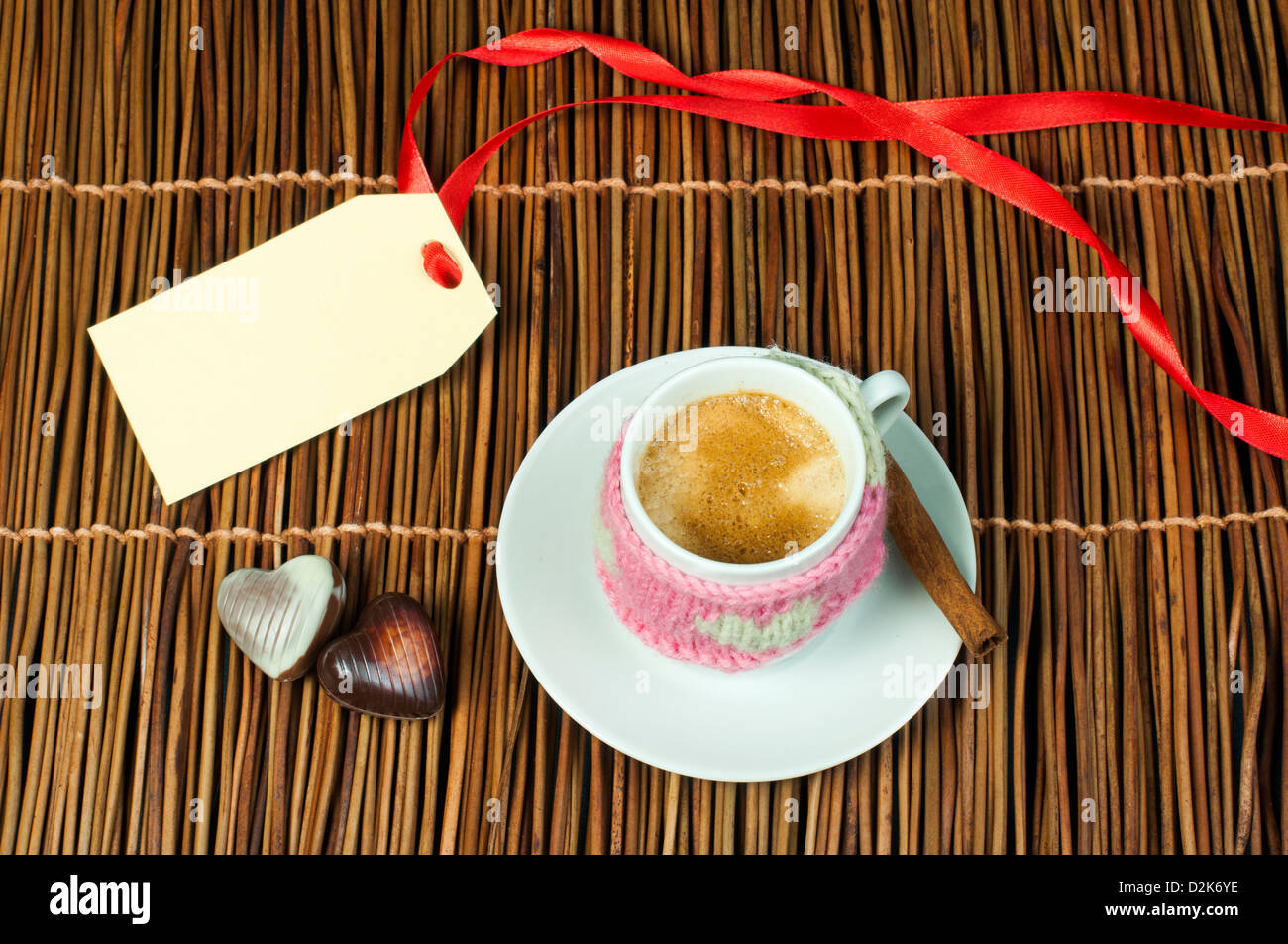 Tasse Kaffee mit gestrickten Herz-Symbol und Beschriftung auf Holzsockel. Stockfoto