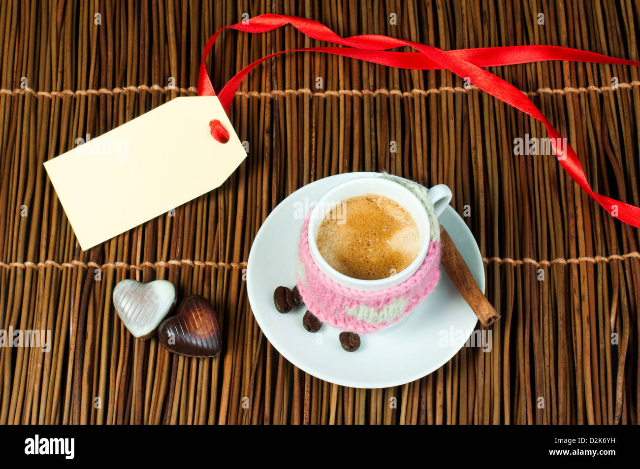 Tasse Kaffee mit gestrickten Herz-Symbol und Beschriftung auf Holzsockel. Stockfoto