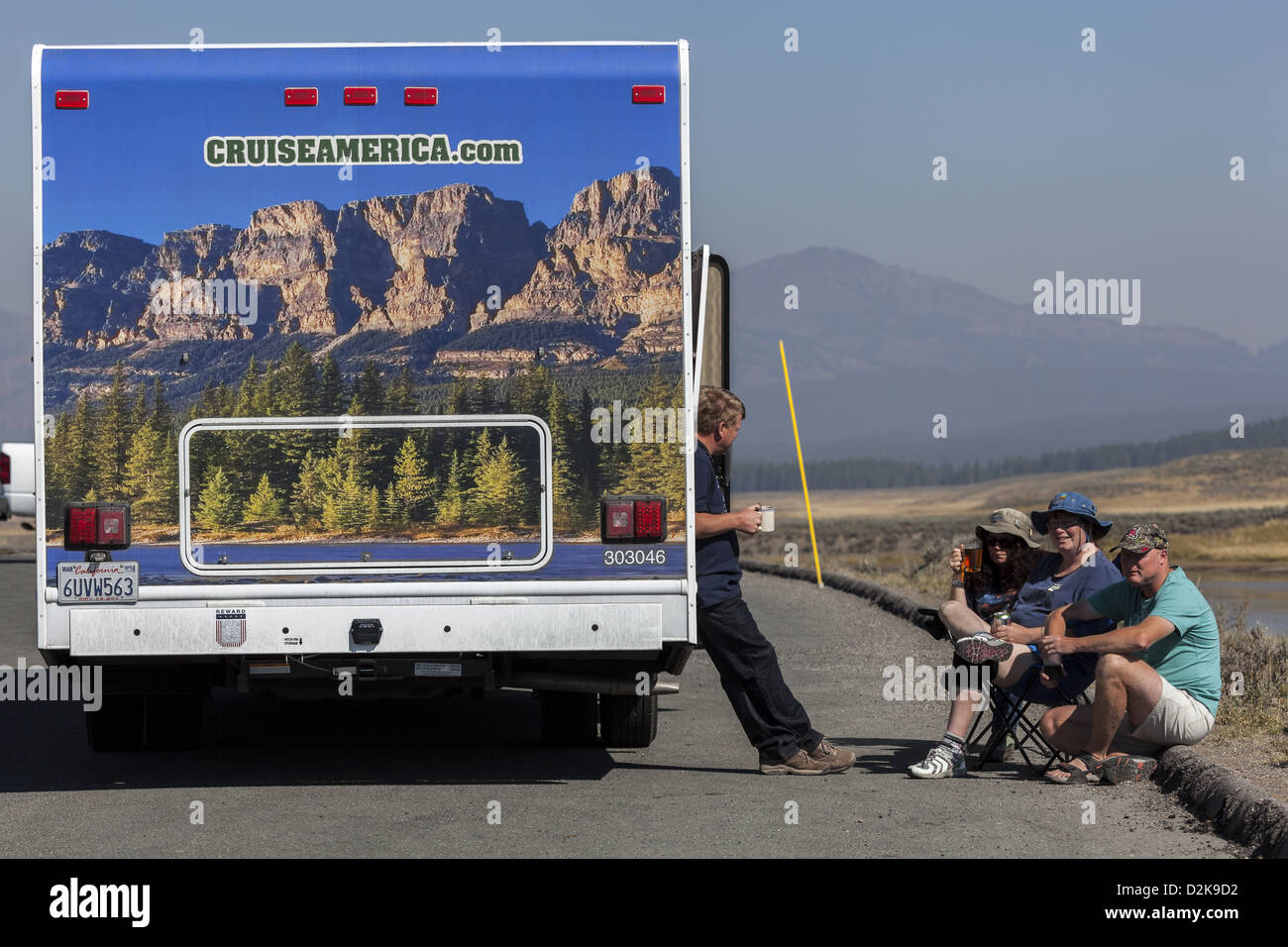 Kreuzfahrt Amerika gemietet Wohnmobil mit Landschaft dekoriert zurück mit dem rv'ers Entspannung neben Fahrzeug in Yellowstone Stockfoto
