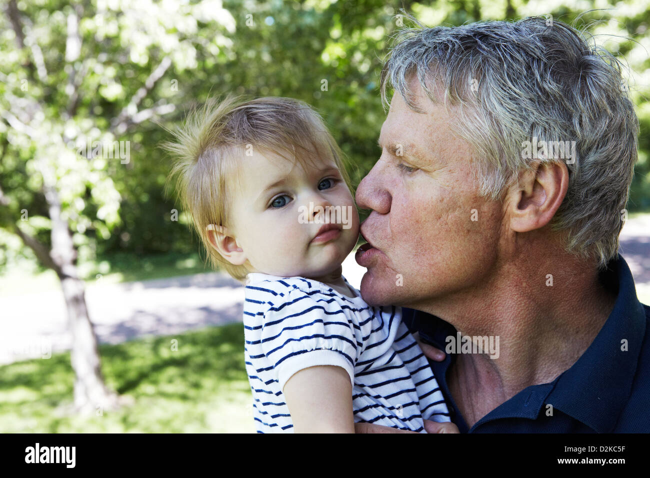 Großvater küssen Baby Enkelin Stockfoto