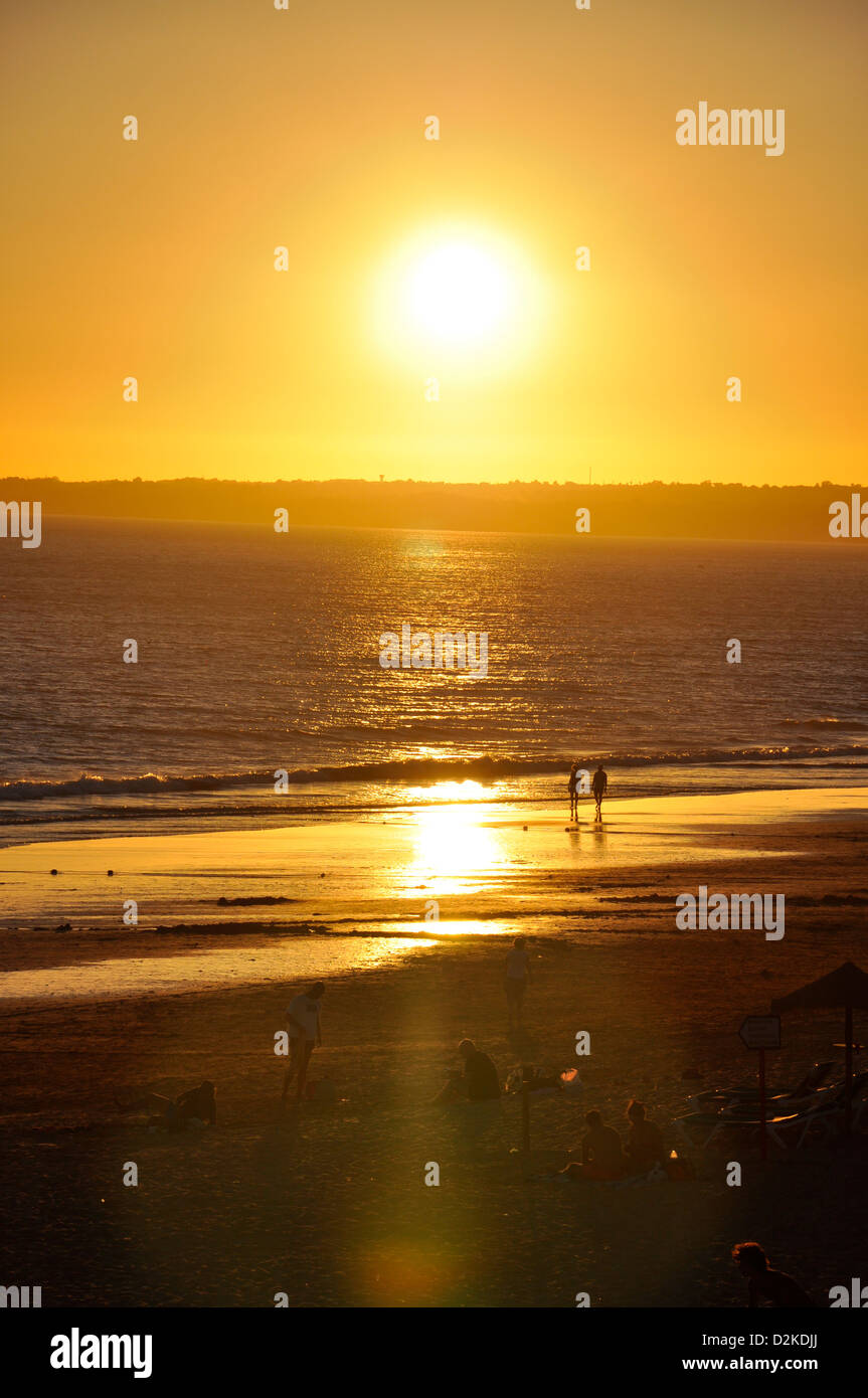 Paare, die am Strand bei Sonnenuntergang in Gale, Region Distrikt Faro, Algarve, Portugal Stockfoto