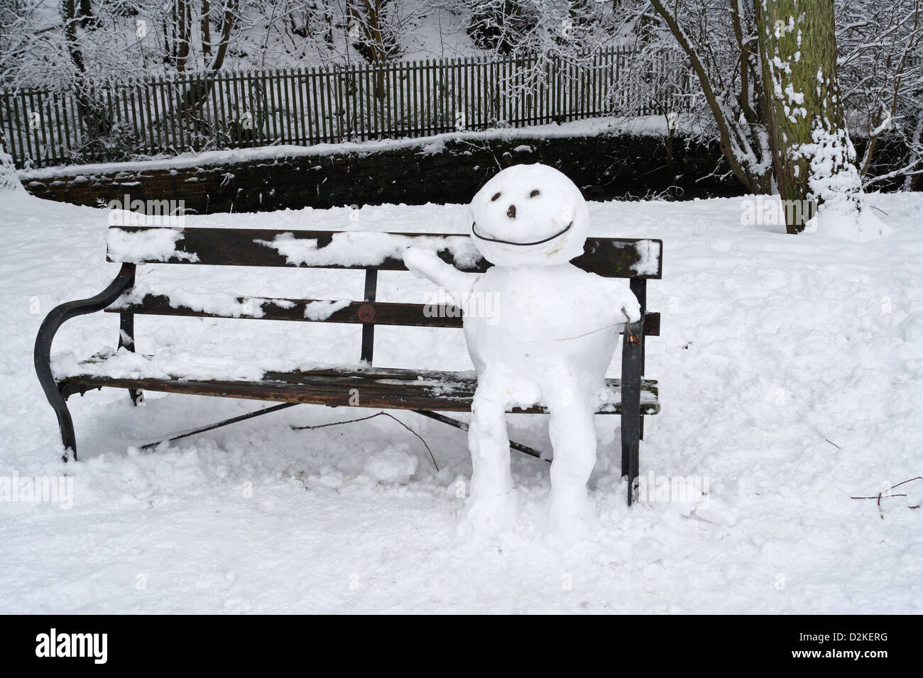 Ein Schneemann, der auf einer Parkbank chillt. Winterschnee Stockfoto
