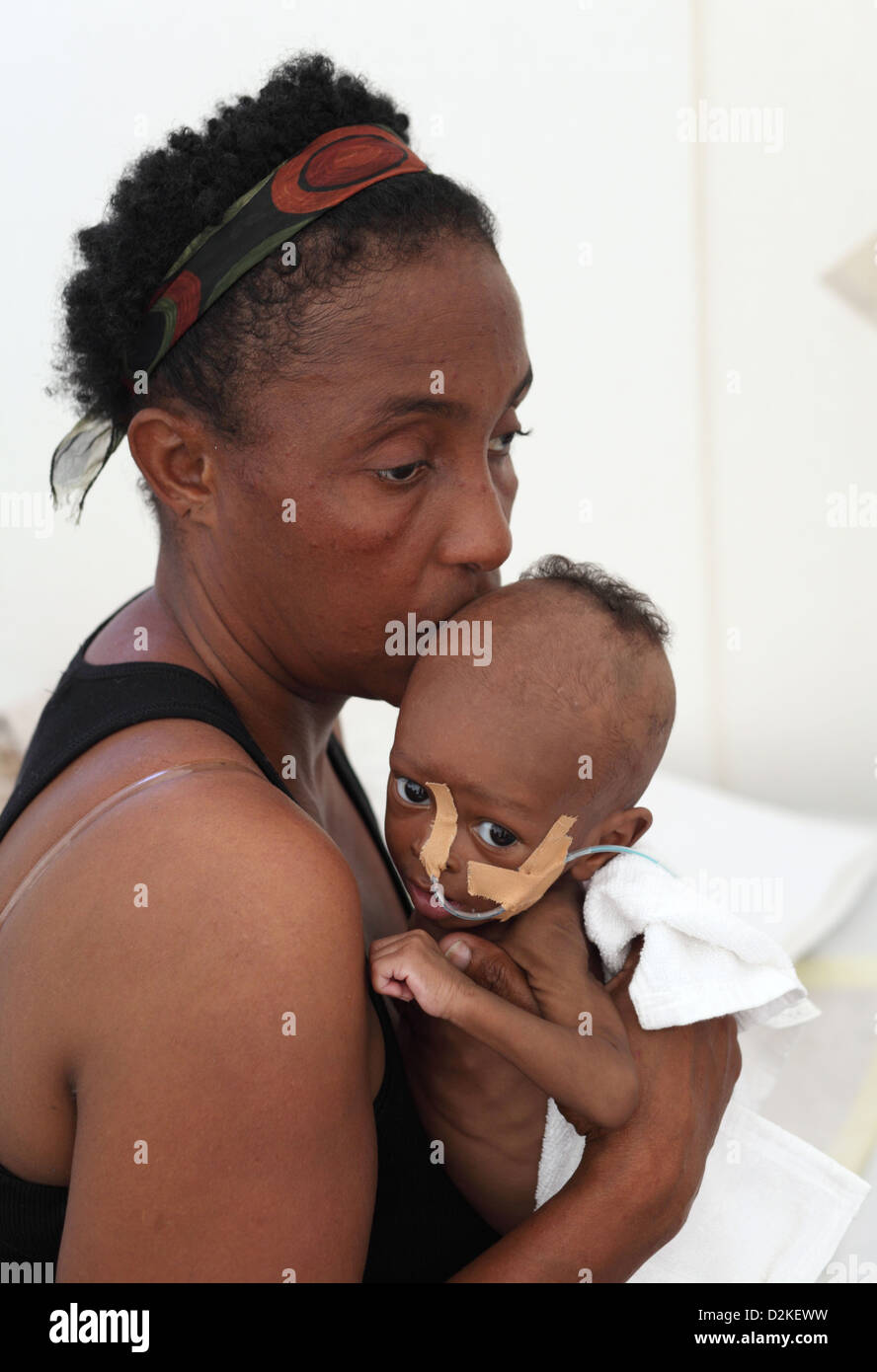 Carrefour, Haiti, eine Mutter, die wiegte sie krank, abgemagert Kleinkind Stockfoto
