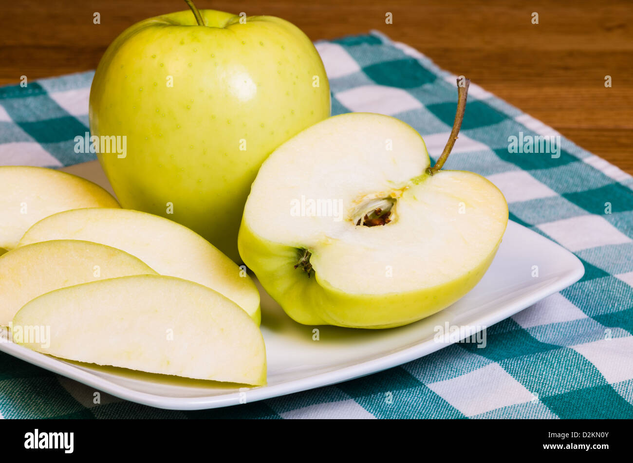 Frischer Golden Delicious Apfel in Scheiben geschnitten auf einem weißen Teller Stockfoto
