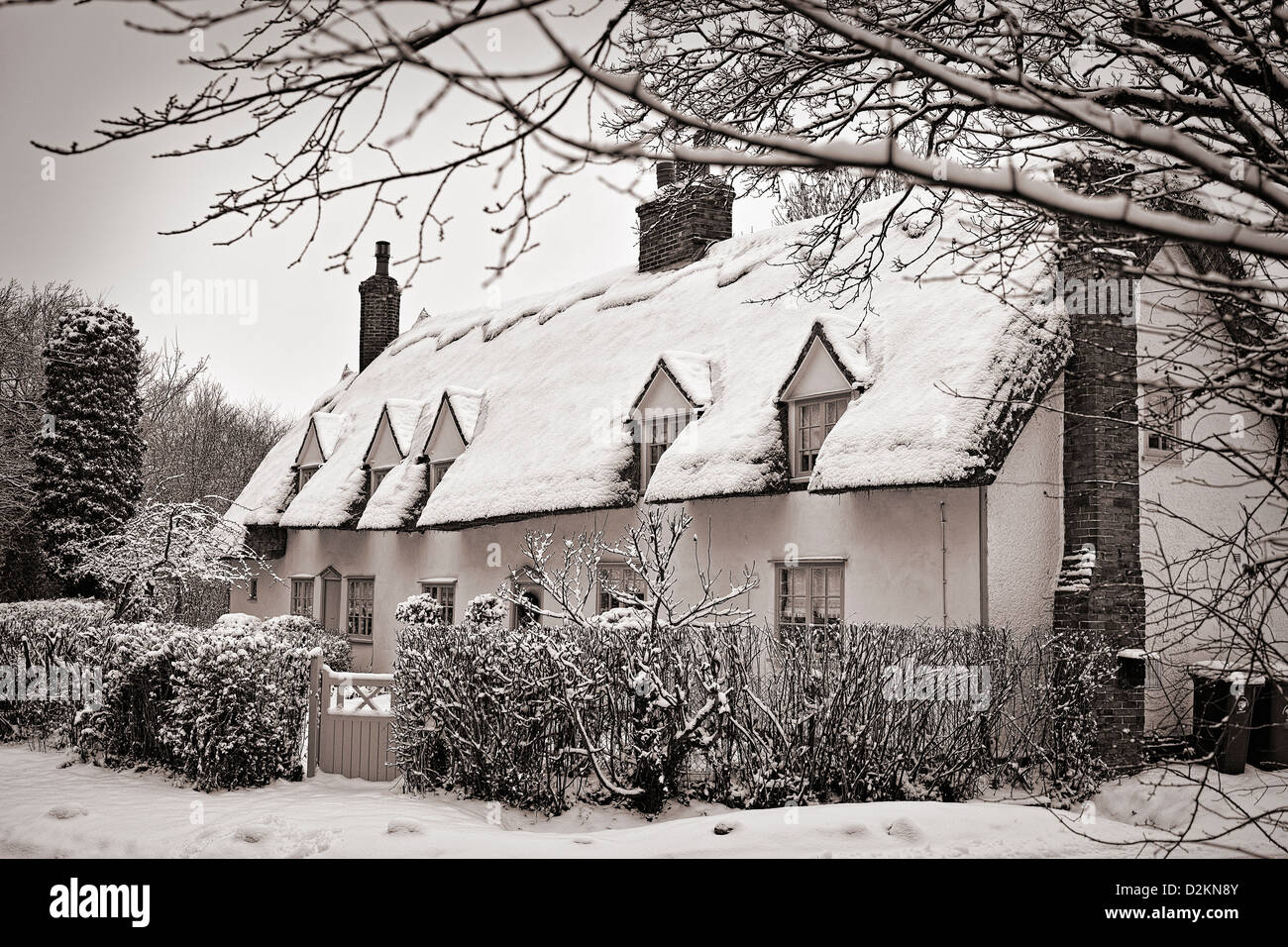 Schneebedeckte Reetdachhaus, leichte Sepia Tönung Stockfoto