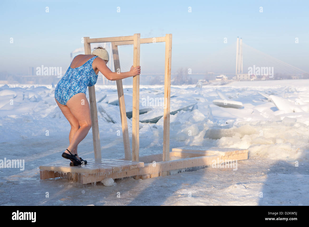 Russische Frau kommt in kaltem Wasser aus Holzbohlen in Epiphany Frost am 19. Januar 2013 in Sankt-Petersburg, Russland. Stockfoto