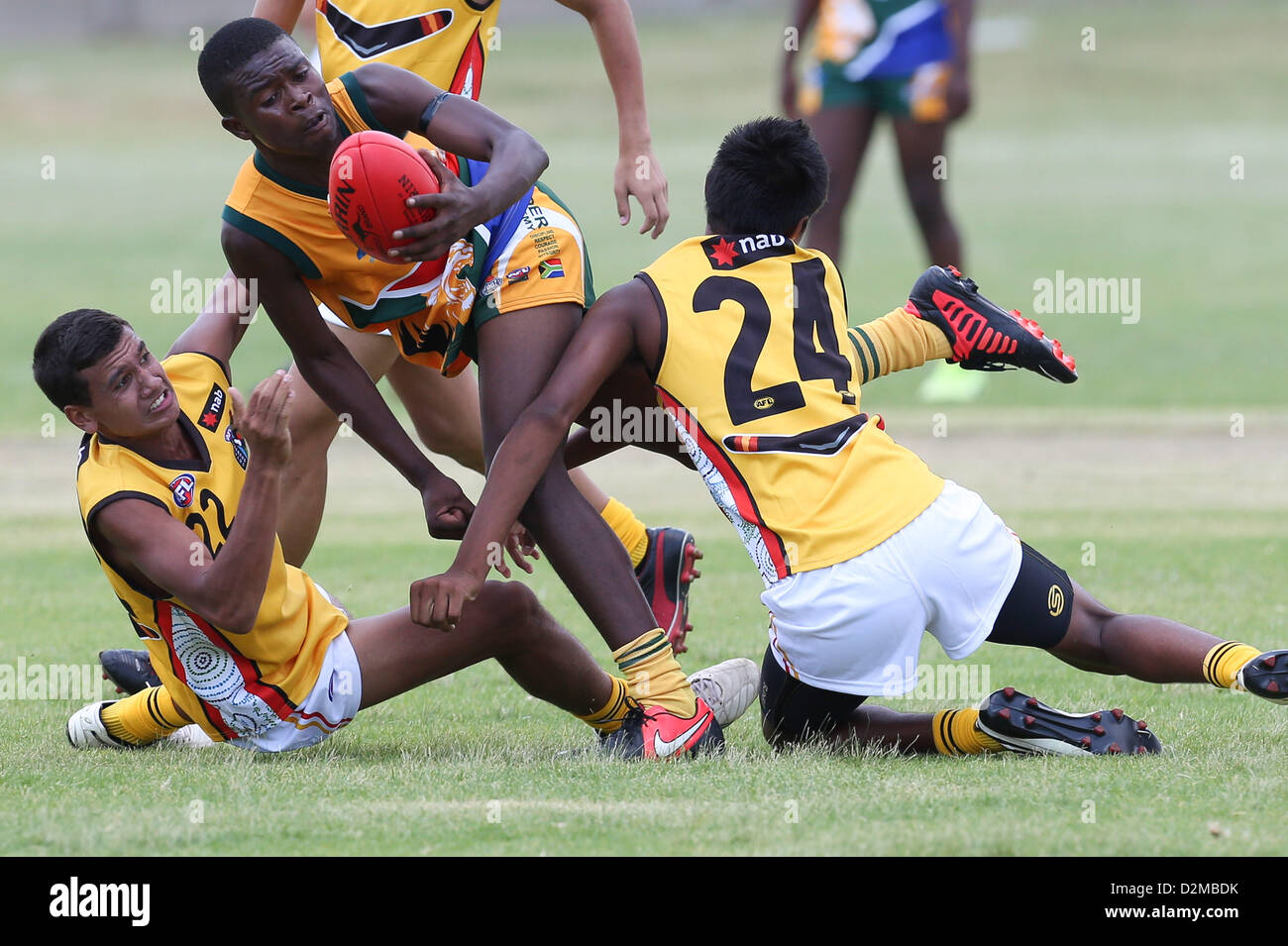 POTCHEFSTROOM, Südafrika - 28.Januar, Moni Yonela (WC Elstern) der SA Löwen wird von Callum AhChee (Armadale, WA) gefangen und Elijah Howard (Waterford, WA) von der australischen Bumerangs in der AFL Spiel 1 match zwischen der fliegende Bumerangs und South African Lions unter 18 Mohadin Cricket Ground am 28. Januar 2013 in Potchefstroom, Südafrika-Foto von Roger Sedres / Bild SA Stockfoto