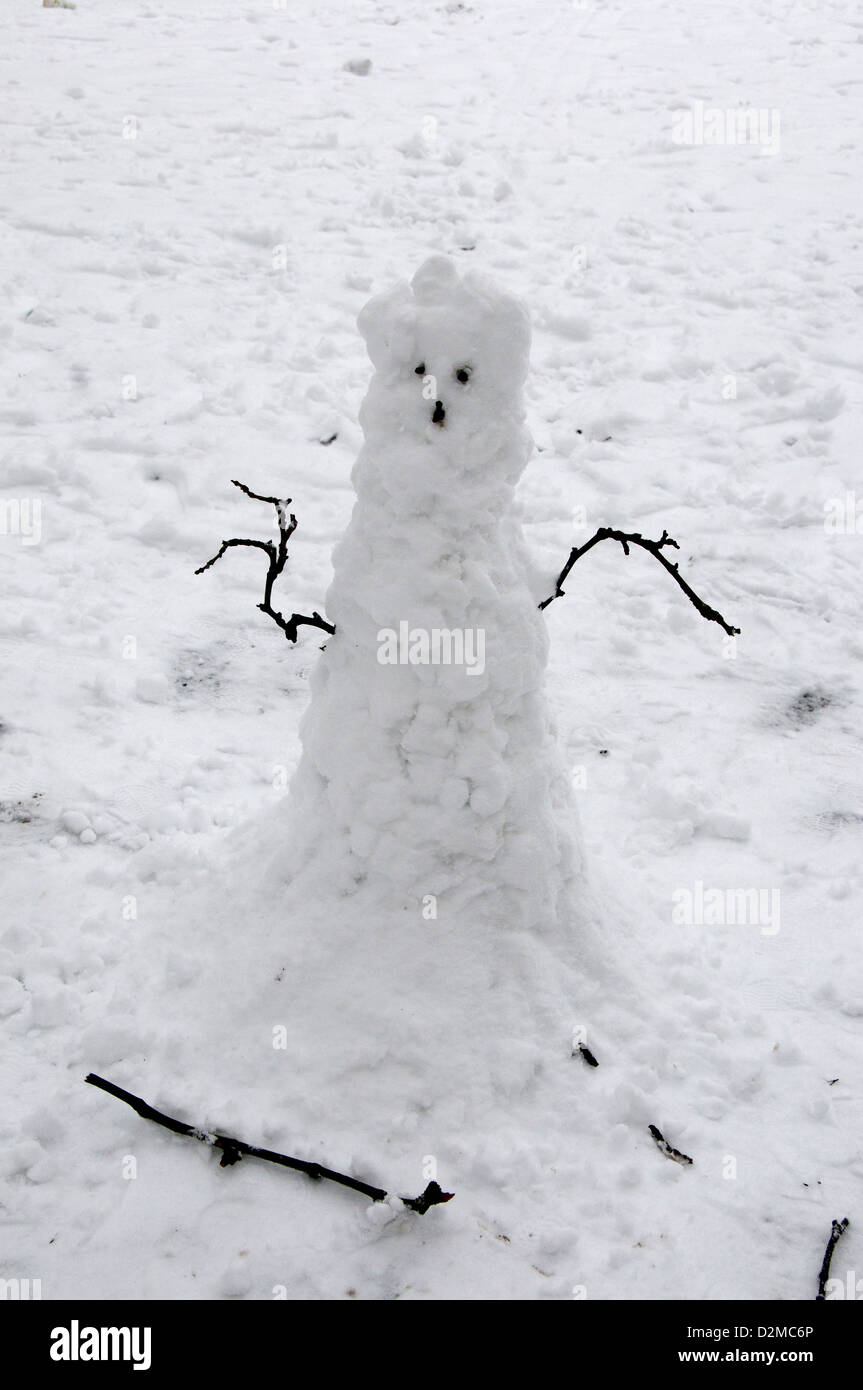 Schneemann mit Zweigen für Arme in den Schnee in London Felder Hackney Stockfoto