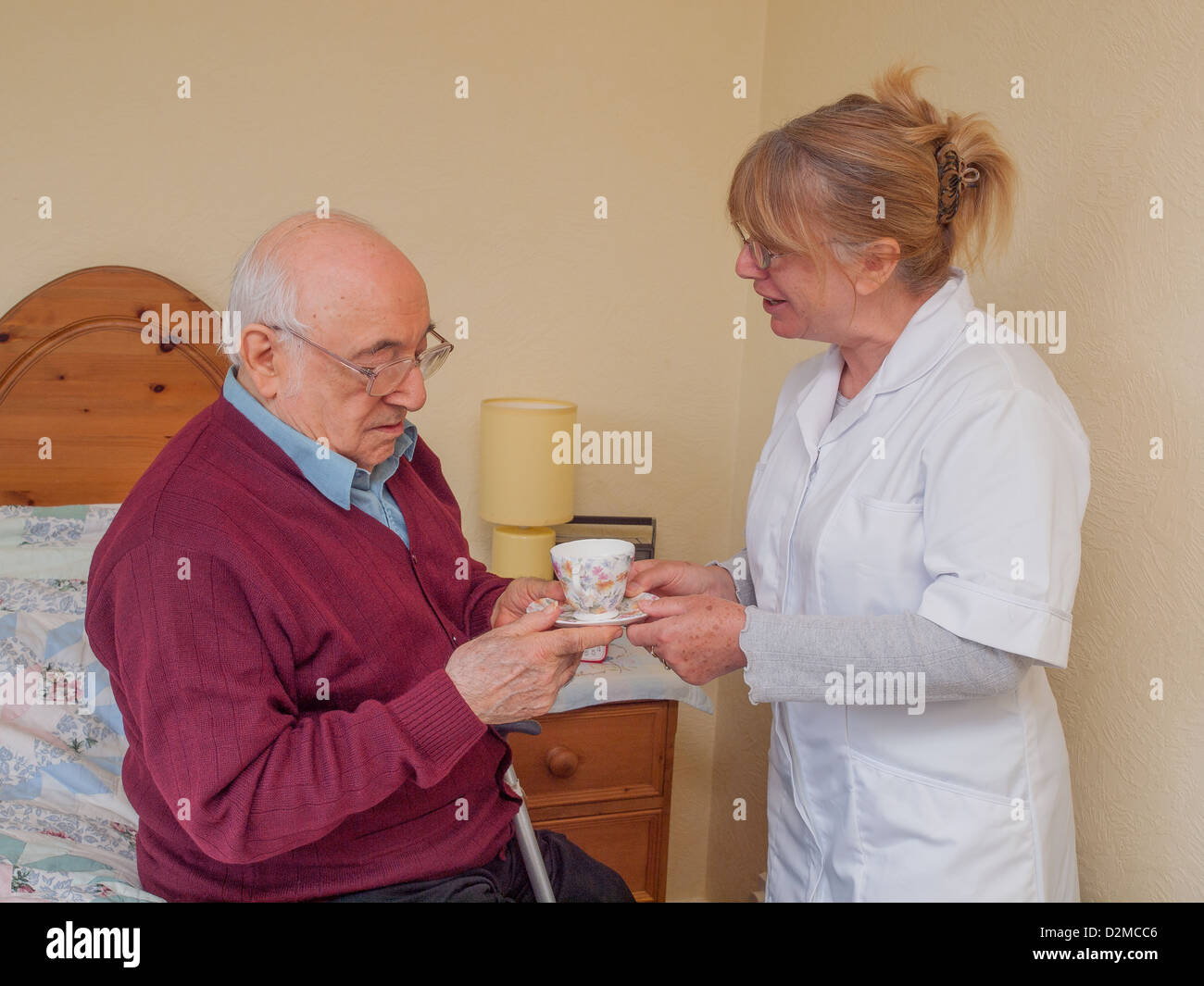 Pflegeperson älterer Herr Tasse Tee verleiht Stockfoto