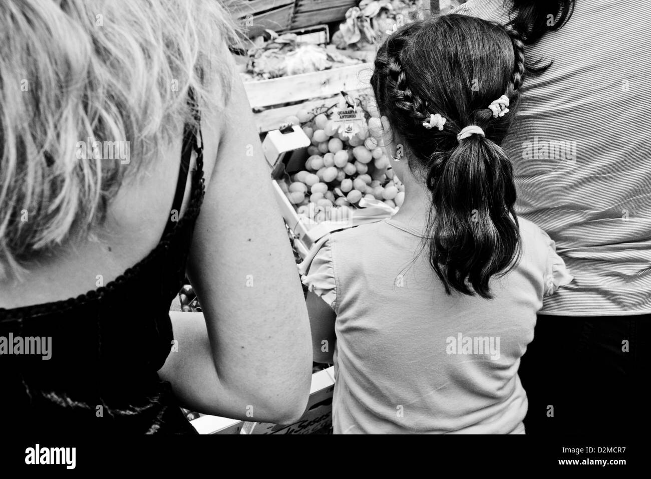 Frauen und ein Mädchen Blick auf Obst im Ballarò-Markt, Palermo, Sizilien Stockfoto
