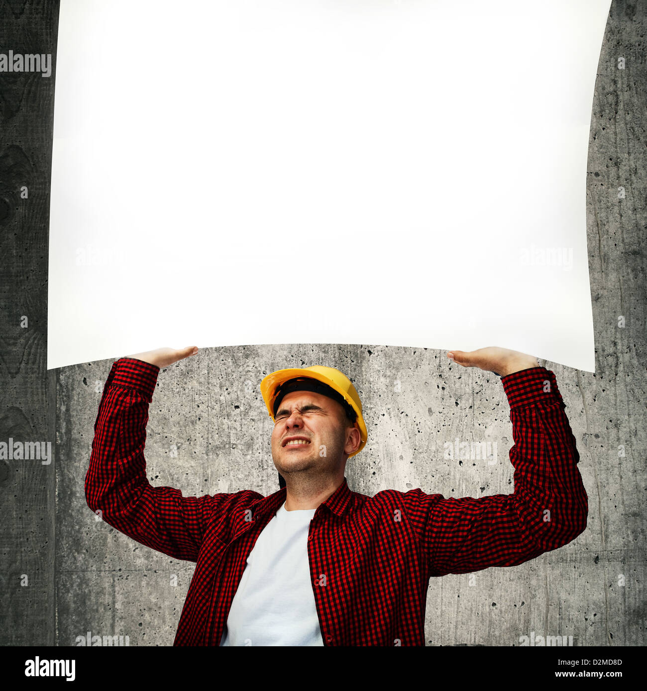 Bauarbeiter mit gelben Schutzhelm im roten Hemd ein Whiteboard über seinem Kopf hält. Stockfoto