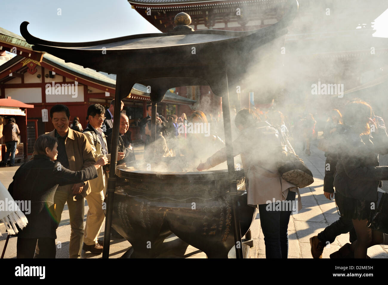 Besuchern und Touristen scharen sich um den Weihrauch-Brenner oder Koro an Sensoji Tempel, Asakusa, Tokio Stockfoto