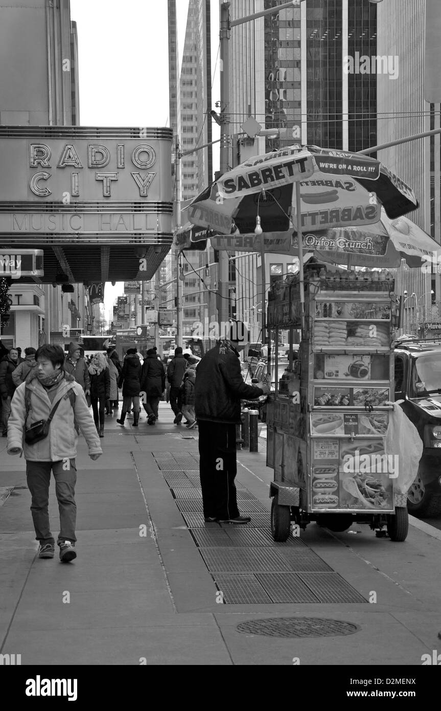 Mann geht durch einen Hot Dog Verkäufer in einer New-York-City-Straße Stockfoto