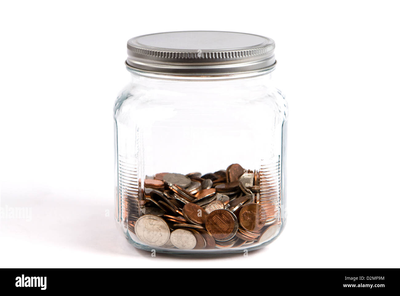 Kleingeld-Glas oder Sparschwein hält Münzen in einem Glasbehälter auf weißem Hintergrund. Stockfoto