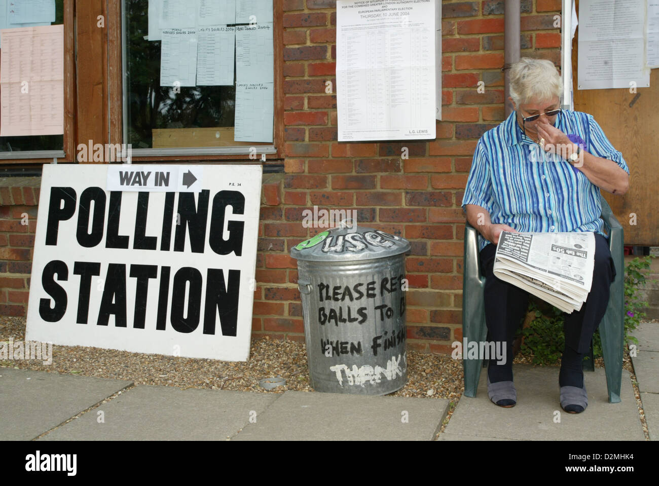 Ein Mann liest eine Zeitung vor einem Wahllokal in London England UK Stockfoto