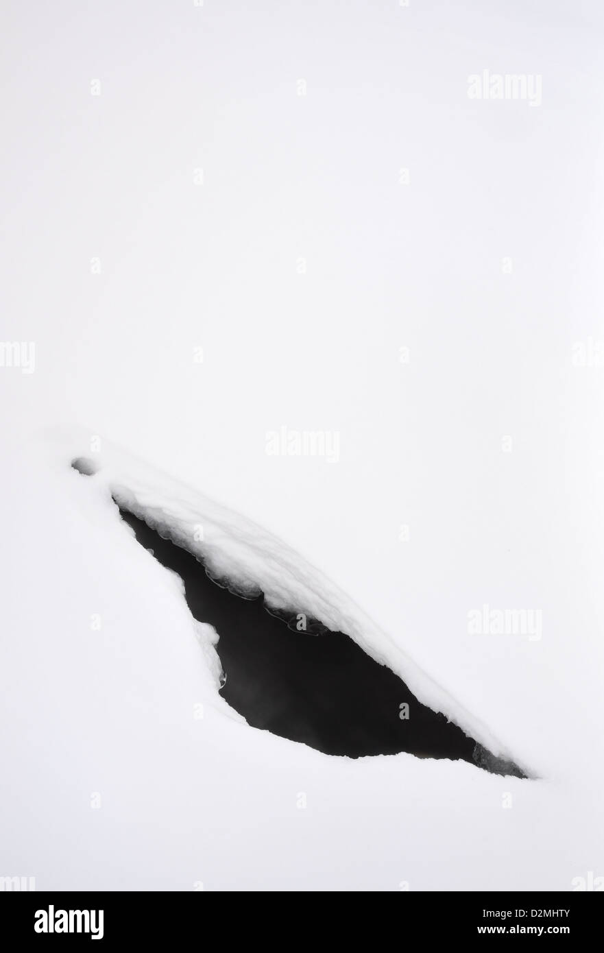 Abstrakte Winterlandschaft. Lücke im gefrorenen Schnee im englischen Lake District Stockfoto
