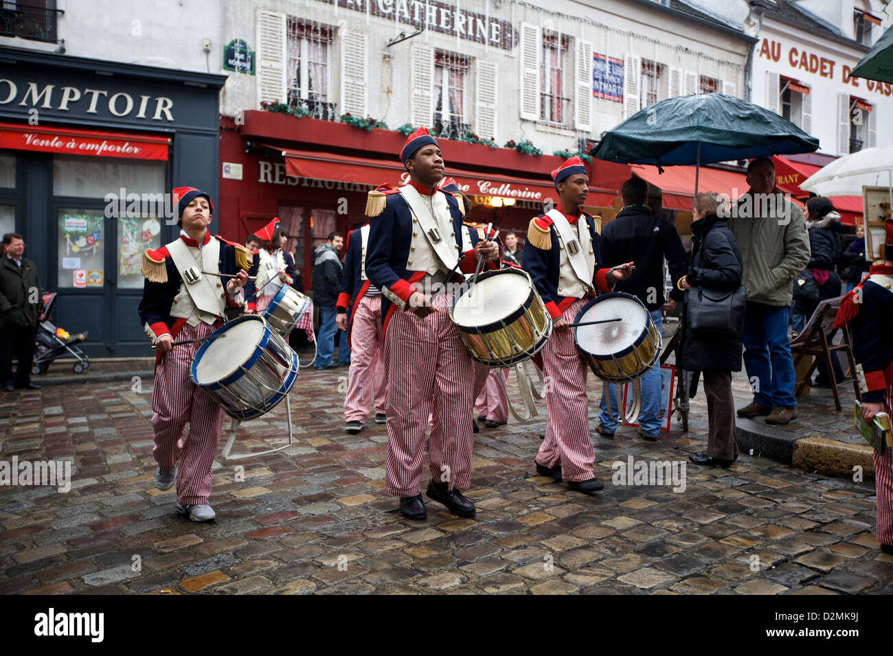 Marching-Bandtrommler in traditionellen Uniformen treten an einem regnerischen Tag in Montmartre, Paris, Frankreich auf Stockfoto