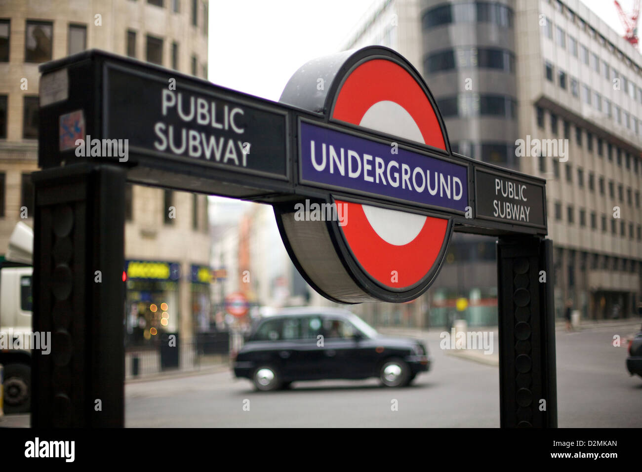 Nahaufnahme eines Londoner U-Bahnschilds an der Bank Station, mit einem traditionellen schwarzen Taxi im Hintergrund, in der City of London, England, Großbritannien Stockfoto