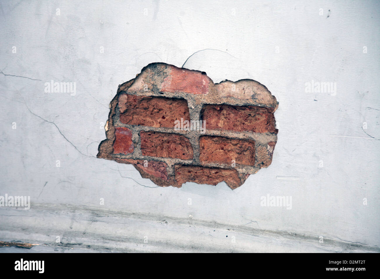 Es ist ein Foto von dem Ende von ein Detail einer zerstörten Mauer. Wir sehen ein Loch in die Ziegel. Es ist ruiniert und alt Stockfoto