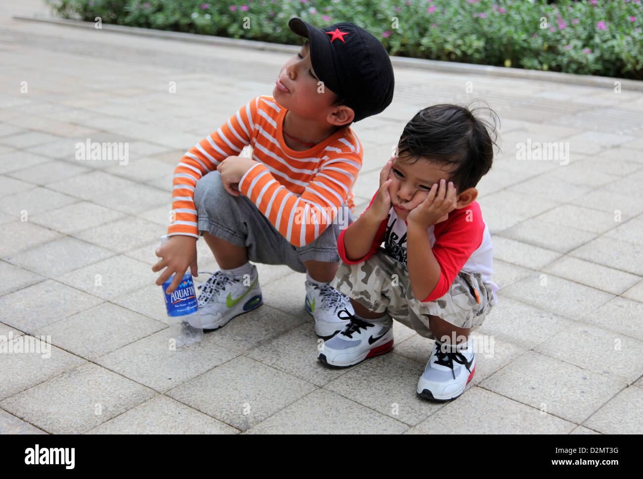 Es ist ein Foto von 2 Kinder, die eine wartende Fußgänger unterwegs und sie sind gelangweilt. Ziemlich langweilig! Stockfoto