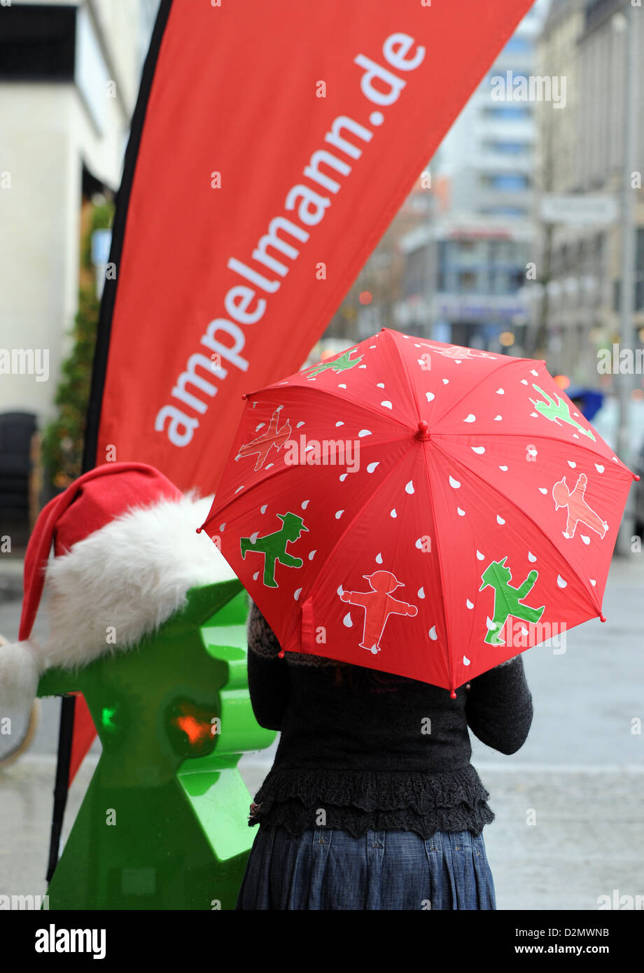 Eine Frau trägt einen Ampelmann-Regenschirm am Gendarmenmarkt in Berlin,  Deutschland, 28. November 2012. Die Ampelmännchen (kleine Ampelmännchen)  Ostdeutschland war die erste Fußgängerampel-Symbol und wurde zu einer Ikone  der "Ostalgie", eine besondere Art