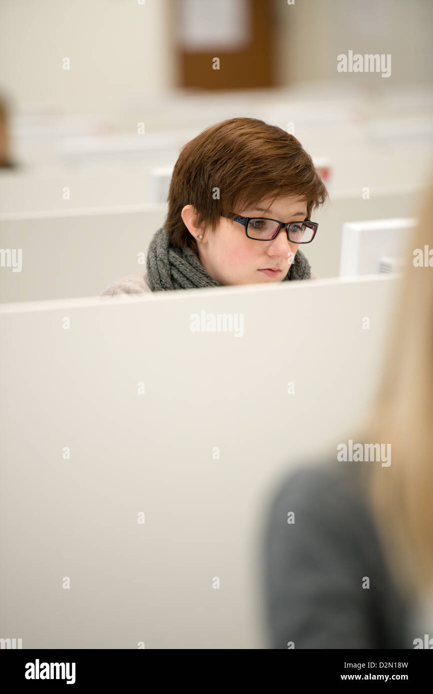 junge Frau trägt Brille und arbeitet mit PC Stockfoto