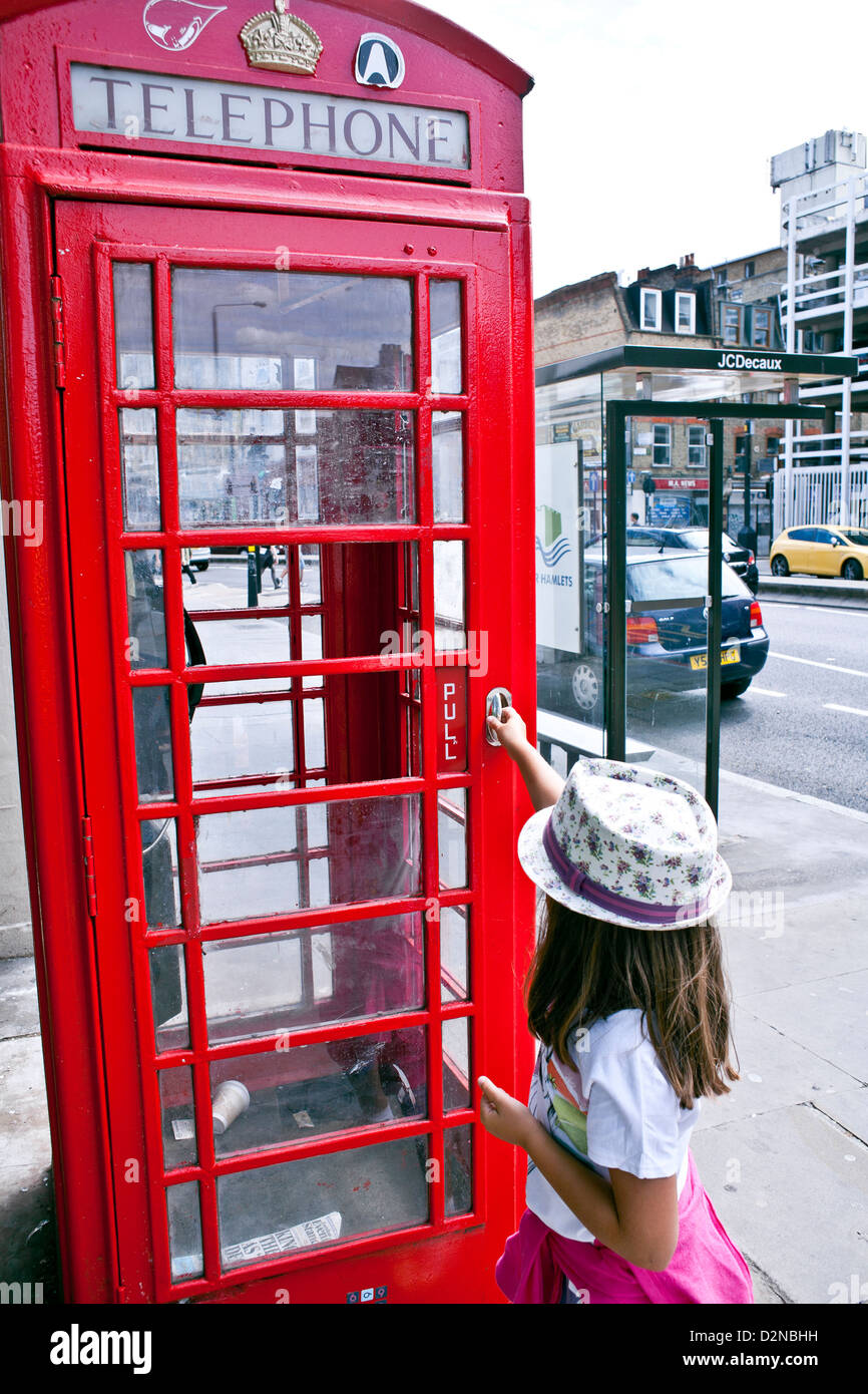 Mädchen in traditionellen rote Telefonzelle in London. Stockfoto