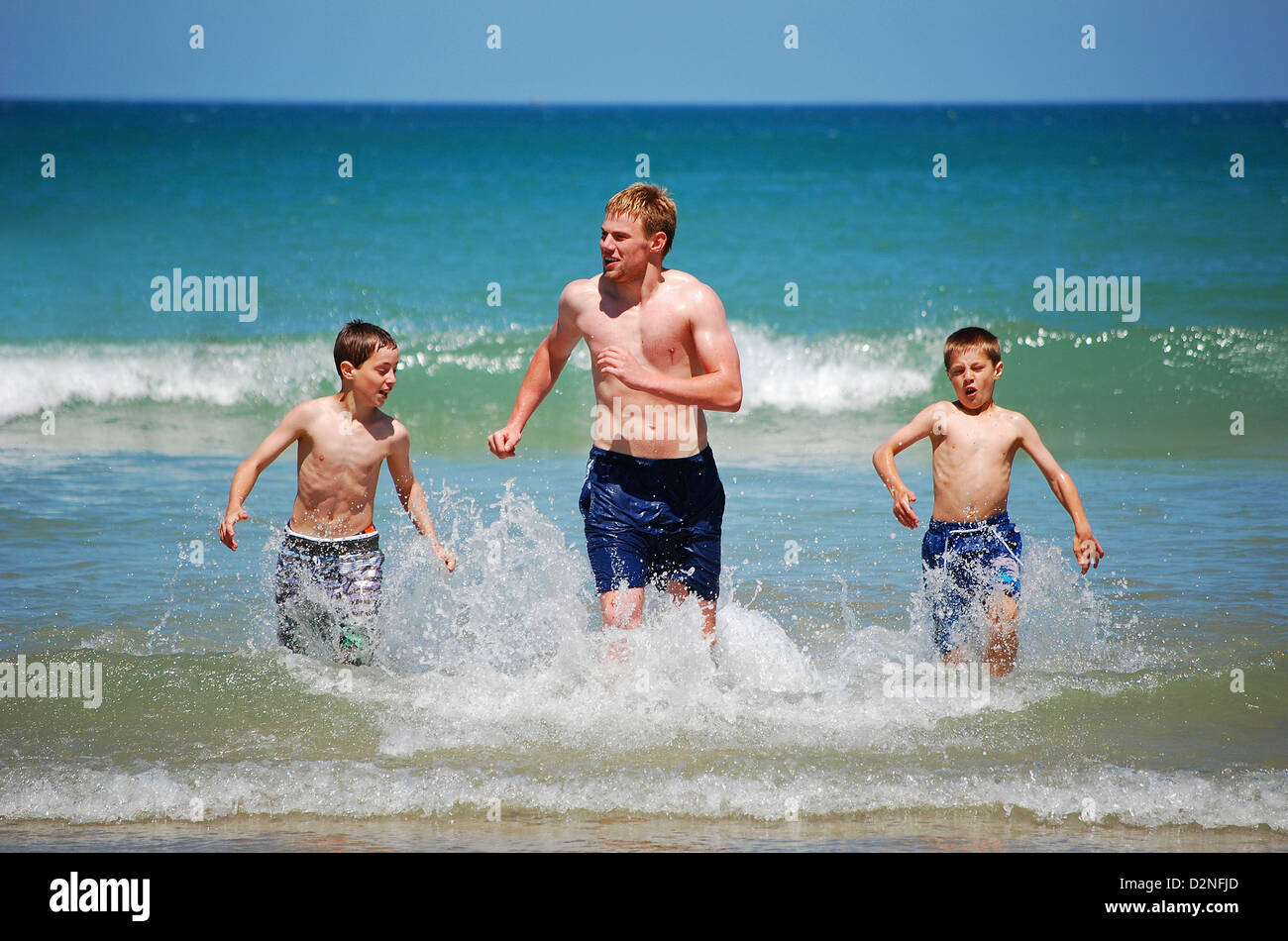 Drei Jungs laufen im Meer Stockfoto
