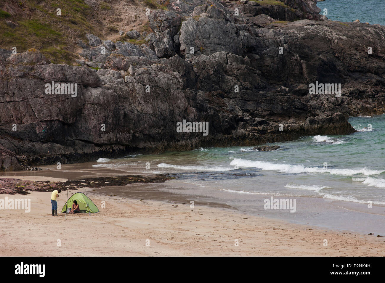 Ein paar Schutz vor dem Wind beim Angeln von einem abgelegenen schottischen Strand im Großraum Sutherland in der Nähe von Cape Wrath Stockfoto