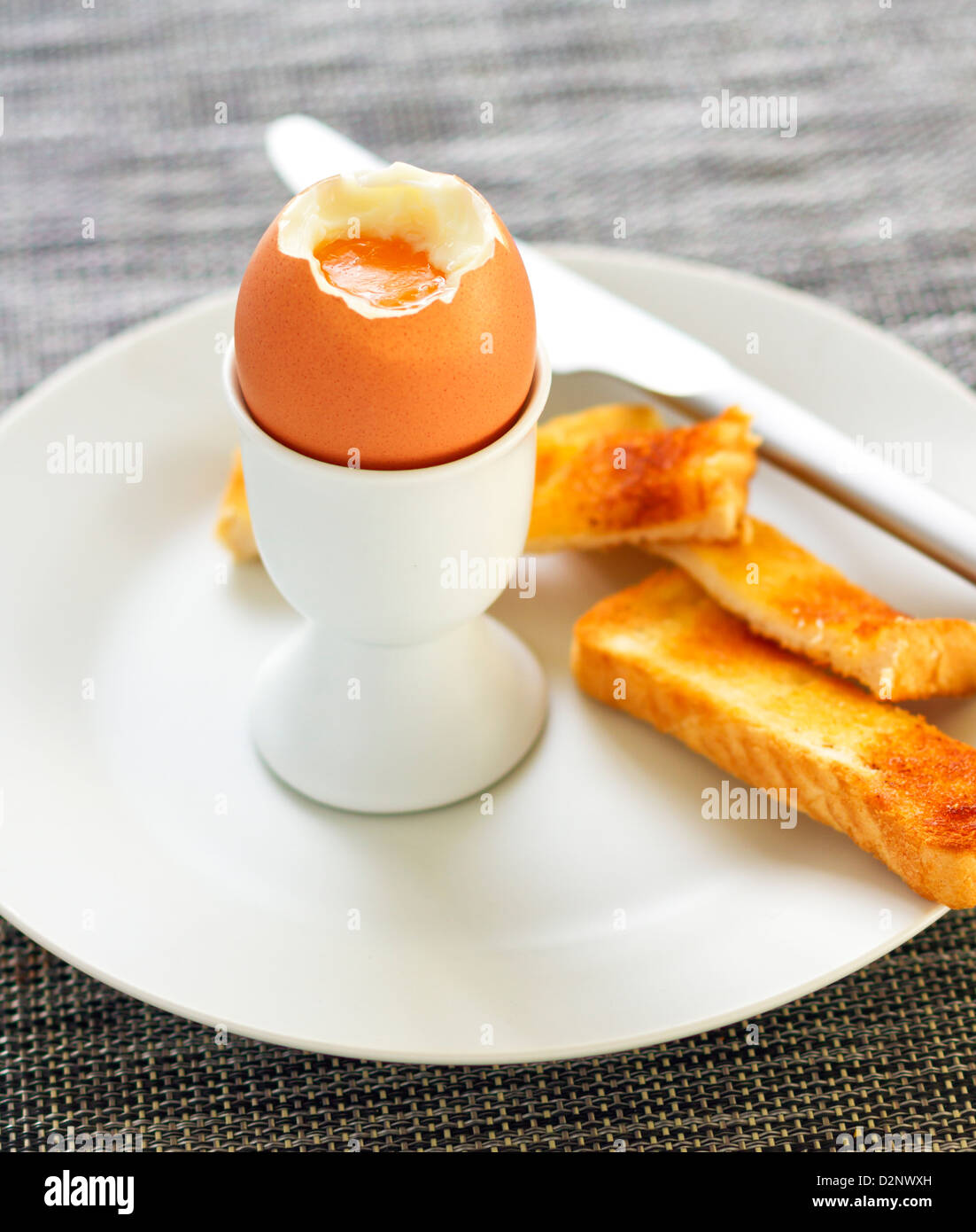 Gekochtes Ei und geröstetem Brot auf einem Teller mit schmalen Brennpunkt Stockfoto