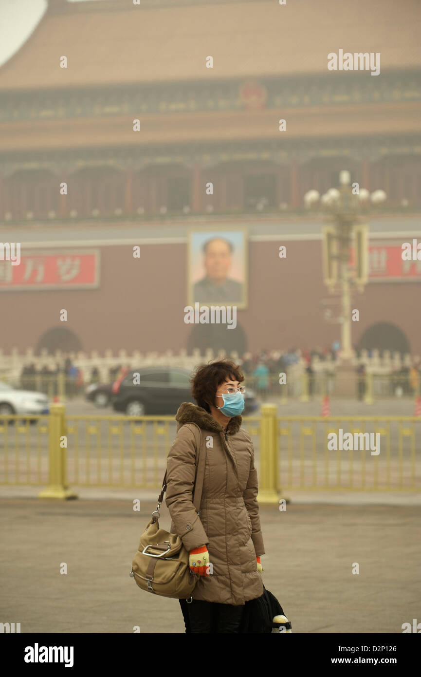 Eine Frau trägt eine Maske auf dem Tiananmen-Platz in dicker Nebel in Peking, China. 30. Januar 2013 Stockfoto