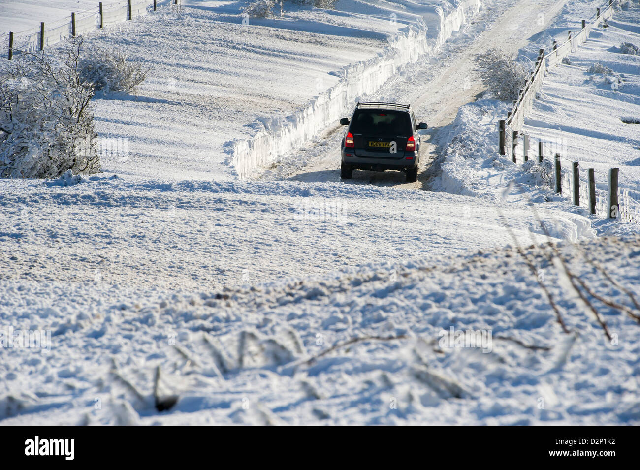 Ein Auto seinen Weg auf die A39 Somerset zwischen Porlock und Lynton, die über Nacht durch Schneeverwehungen, UK blockiert wurde Einfassung Stockfoto